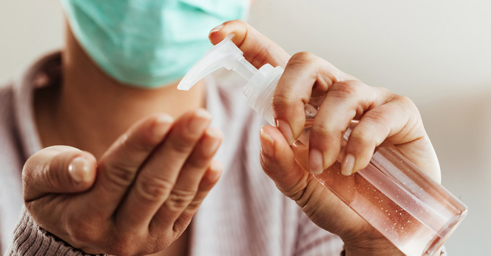 Medidas de prevenção contra a Covid-19: mulher higienizando as mãos com álcool em gel
